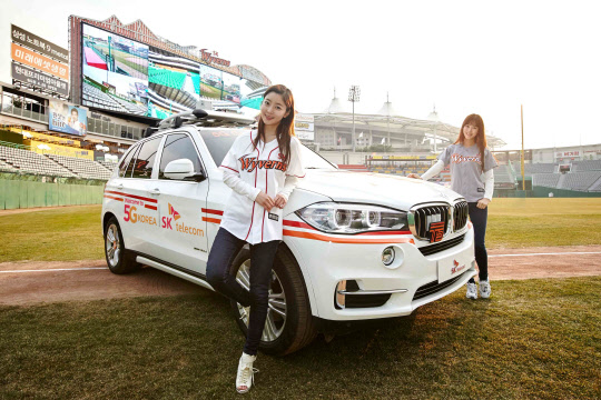 SK텔레콤은 인천시 문학동 SK구장에 대규모 5G 테스트베드를 구축하고, 프로야구 개막에 맞춰 31일부터 내달 2일까지 사흘간 '5G 스타디움'을 시연한다고 28일 밝혔다. 회사 모델이 개막전이 열리는 31일 시구자가 타고 등장할 5G 커넥티드 카 T5를 소개하고 있다. <SK텔레콤 제공>